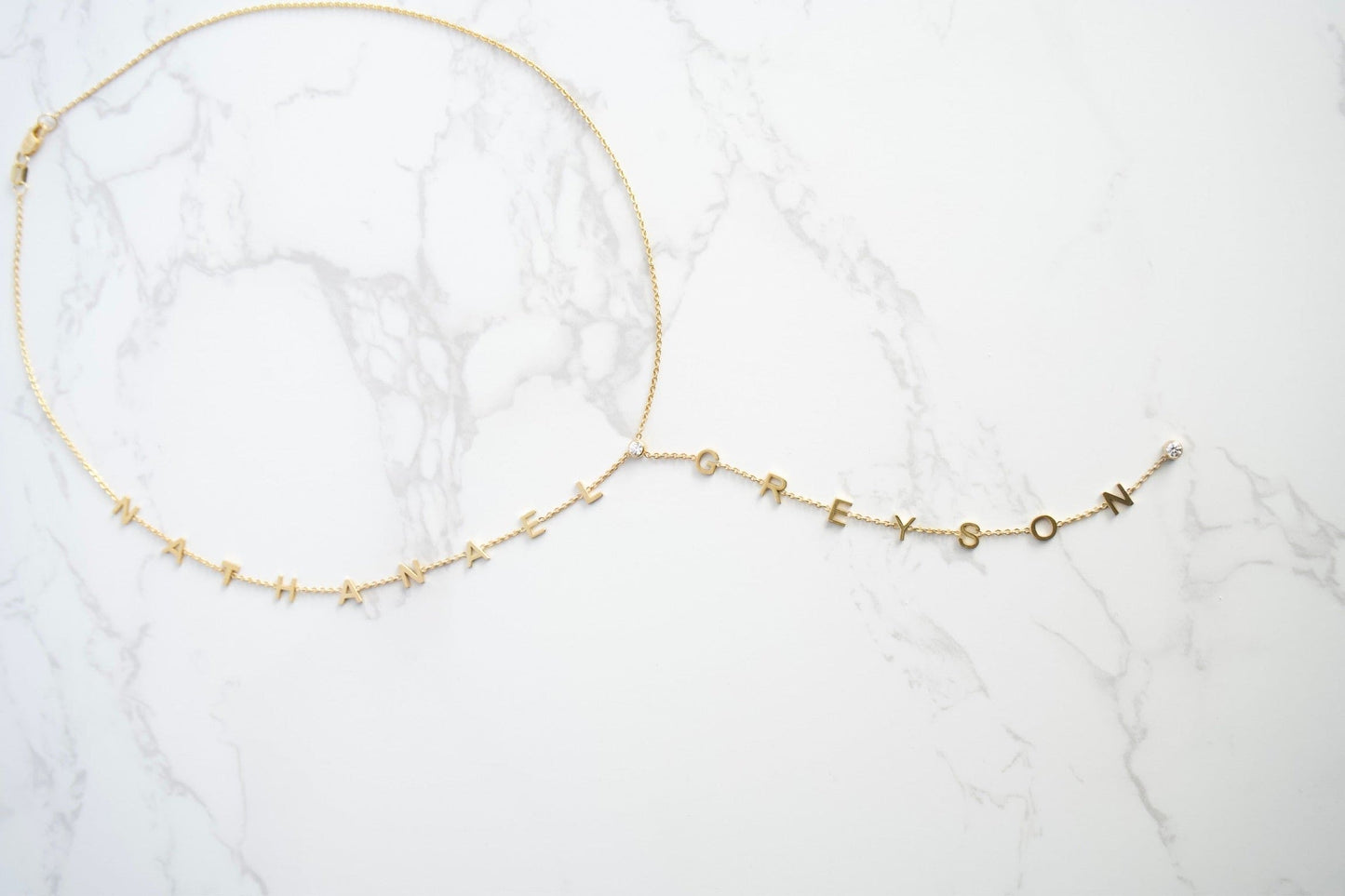Gold necklace on a white marble surface