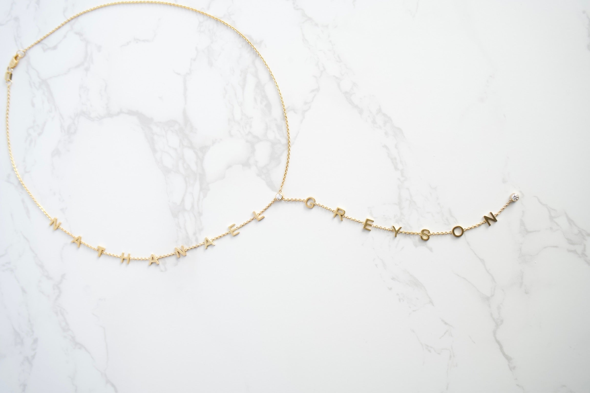 Gold necklace on a white marble surface