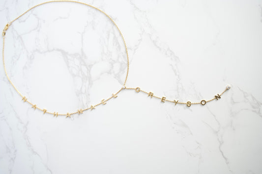 Gold necklace on a white marble surface