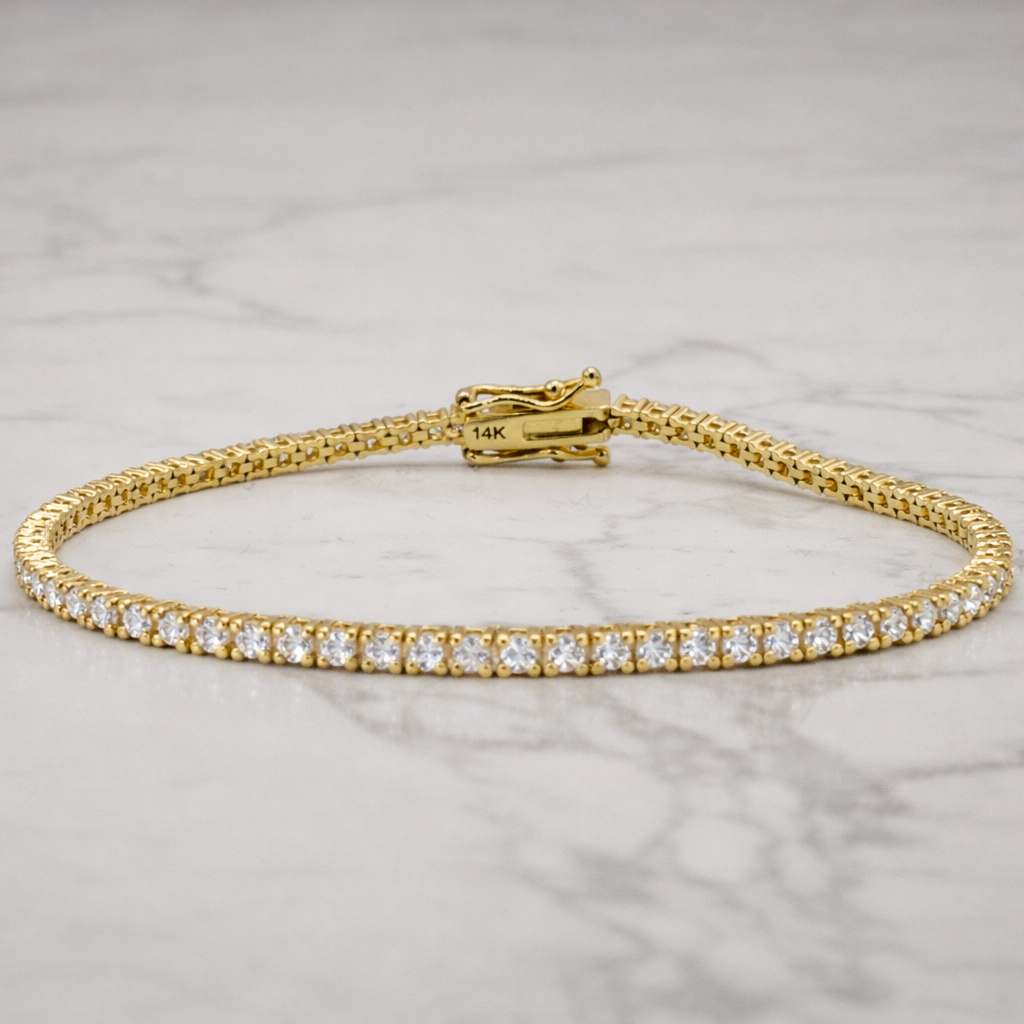 Gold bracelet with diamonds on a marble surface