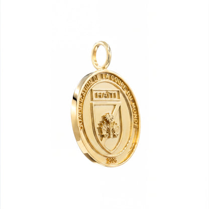 Gold pendant with 'Haiti' and 'Qualification de la Coupe du Monde' text on a white background